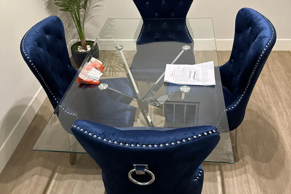 Glass dining table with blue velvet chairs assembled