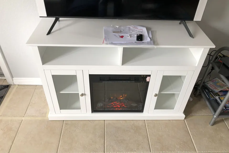 White electric-fireplace TV stand assembled with a TV on top