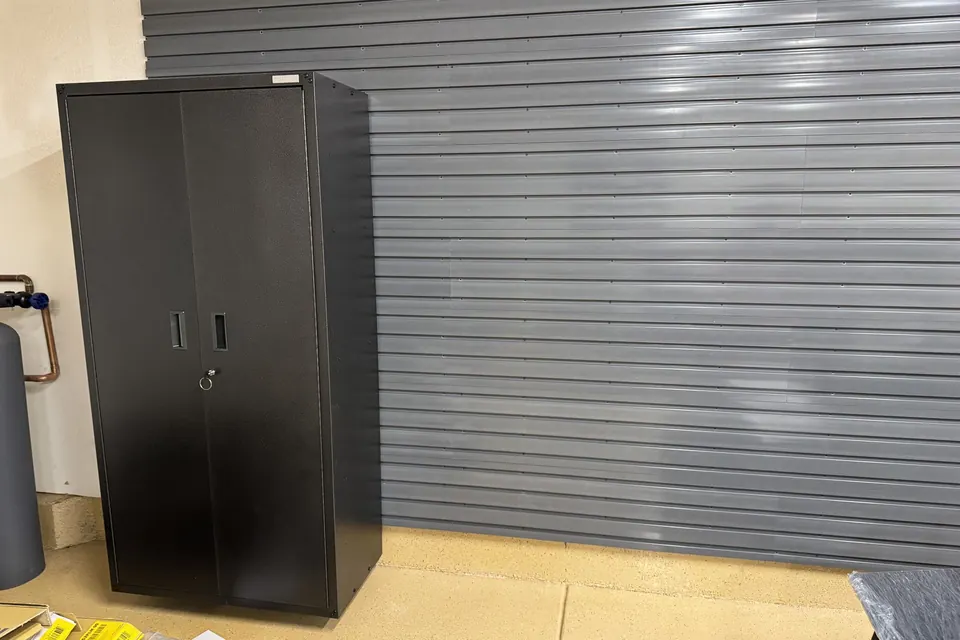 Garage slatwall wall panels with a black metal storage cabinet