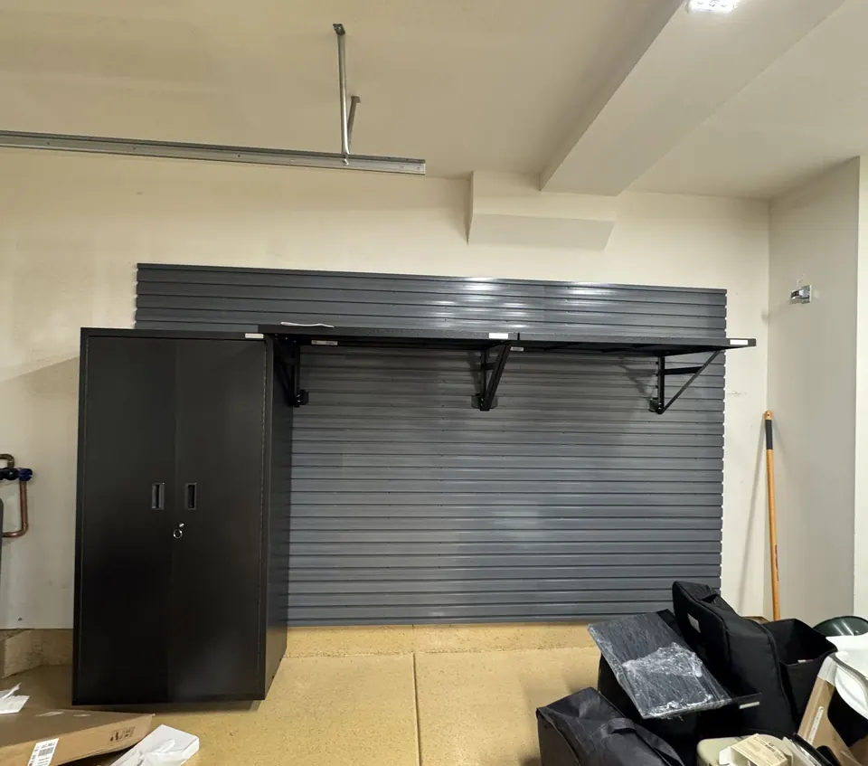 Wall-mounted slatwall and shelf installed in a garage
