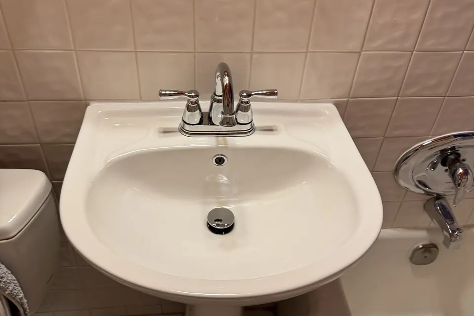 Newly installed white pedestal sink and faucet