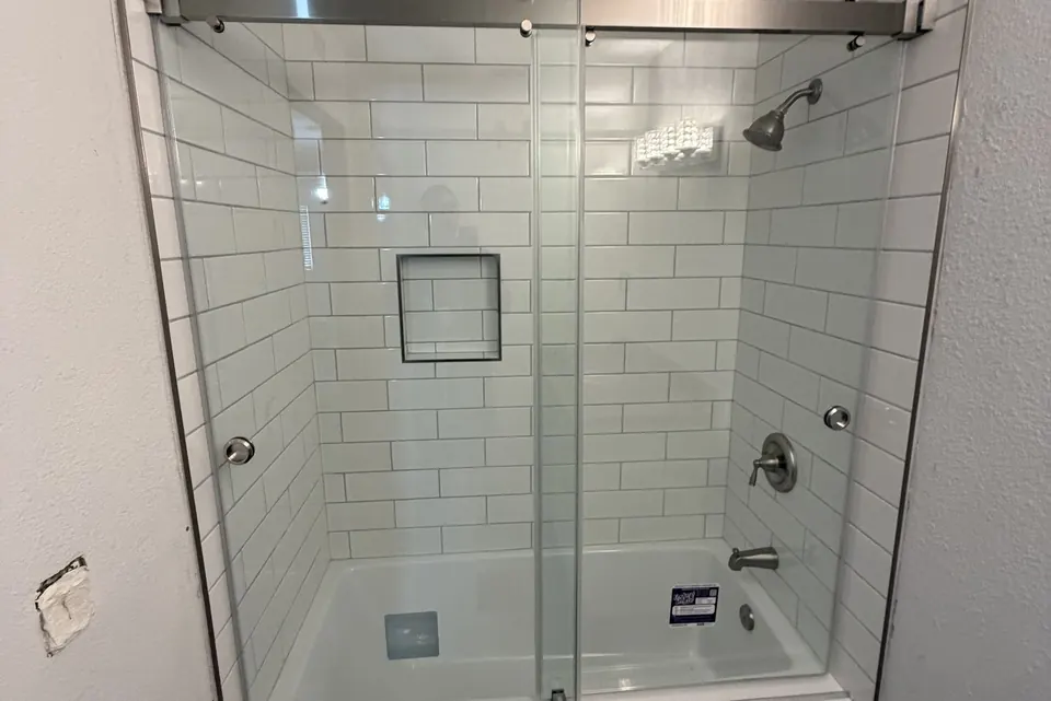 Glass sliding shower door installed over a bathtub