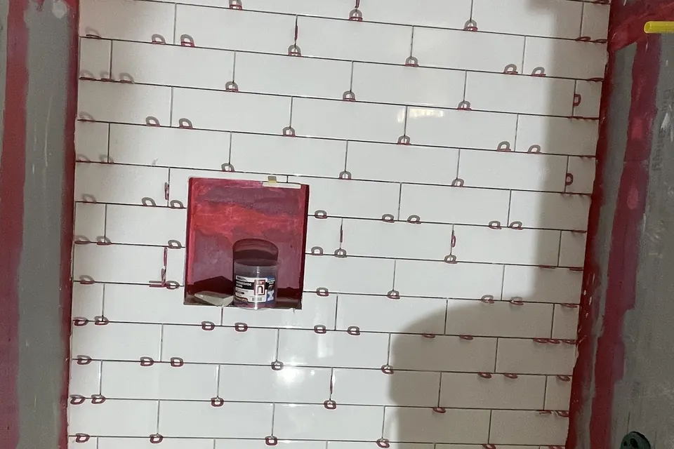 Shower wall tile being set with spacers