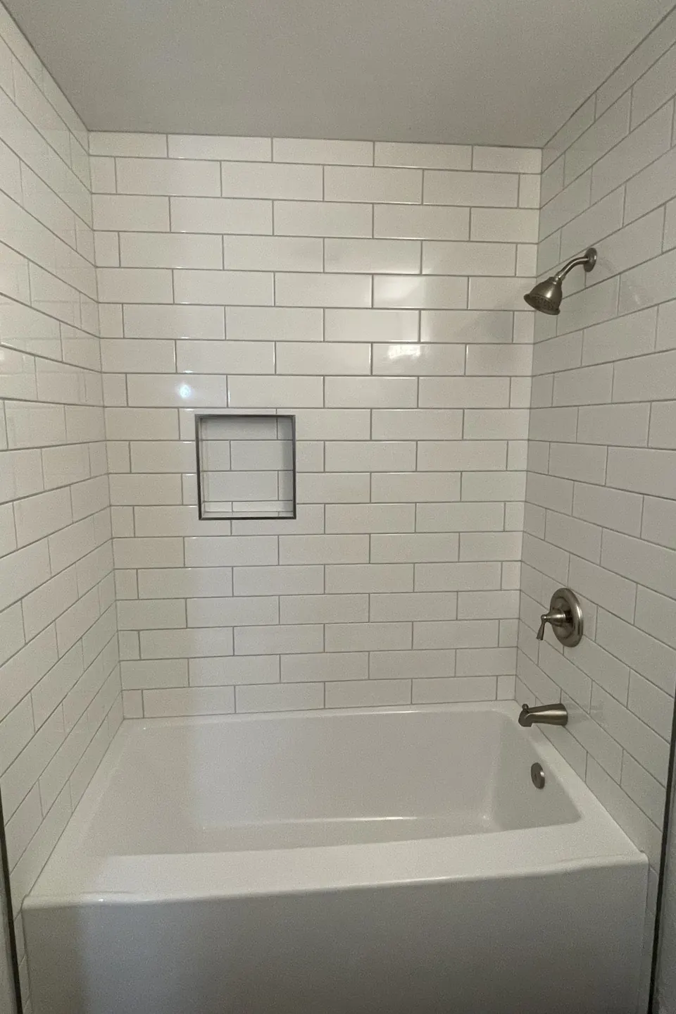Finished white subway-tile shower and tub surround